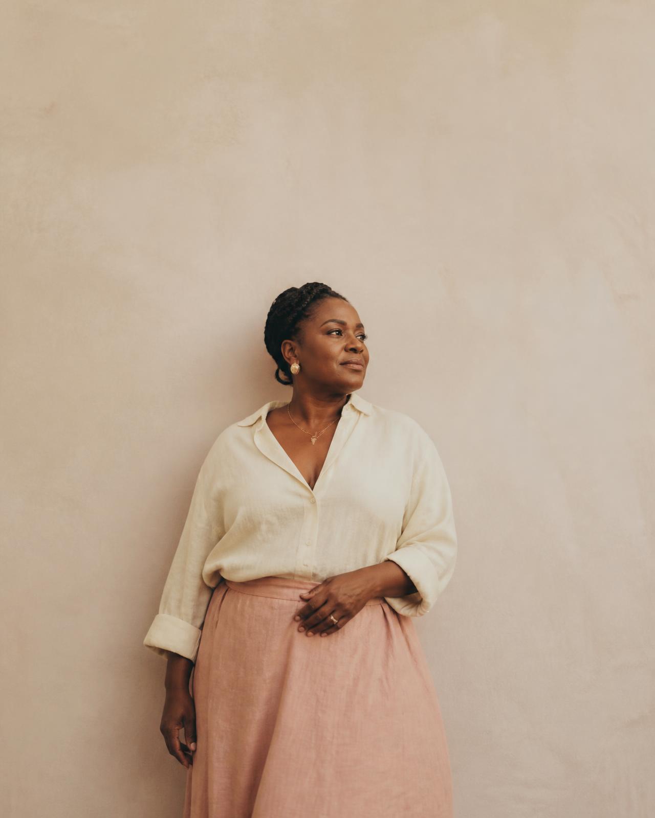 Carrissa, founder of Keep Me Curvy, standing against a warm cream wall